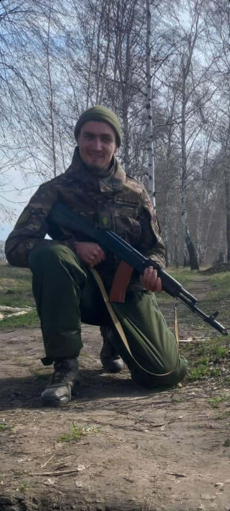 Молодий хлопець стоїть на одному коліні, в руках у нього 