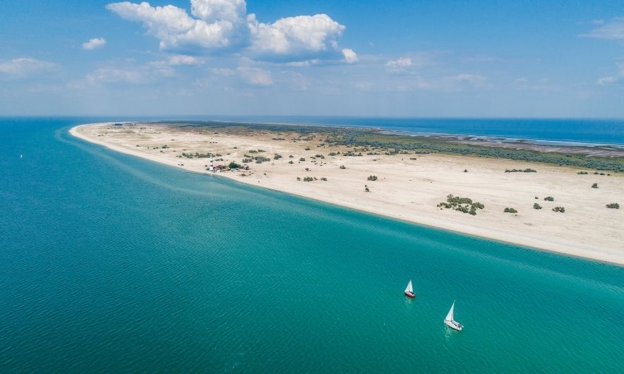 Довге узбережжя Тендрівської коси. Уздовж нього пливуть яхти