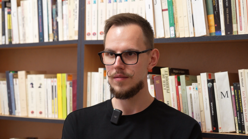 Ярослав Ченцов на фоні книжкової полиці