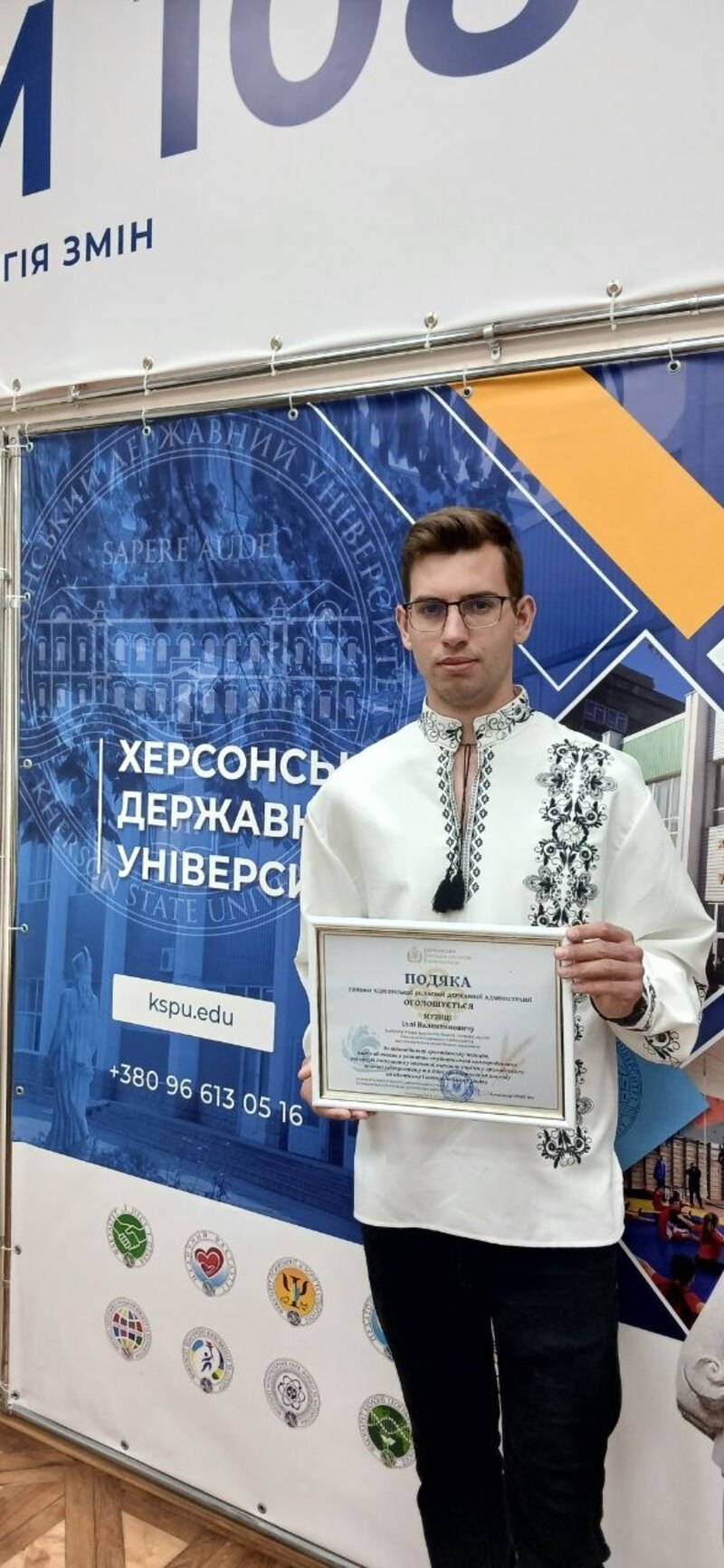 Студент ХДУ Ілля Музика стоїть із грамотою в руках