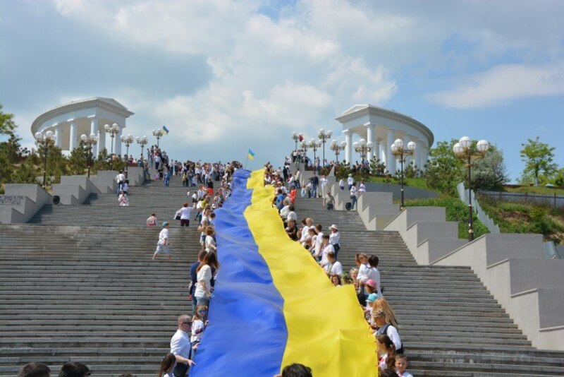 Люди тримають величезний прапор України, розтягнений уздовж сходів у Чорноморську