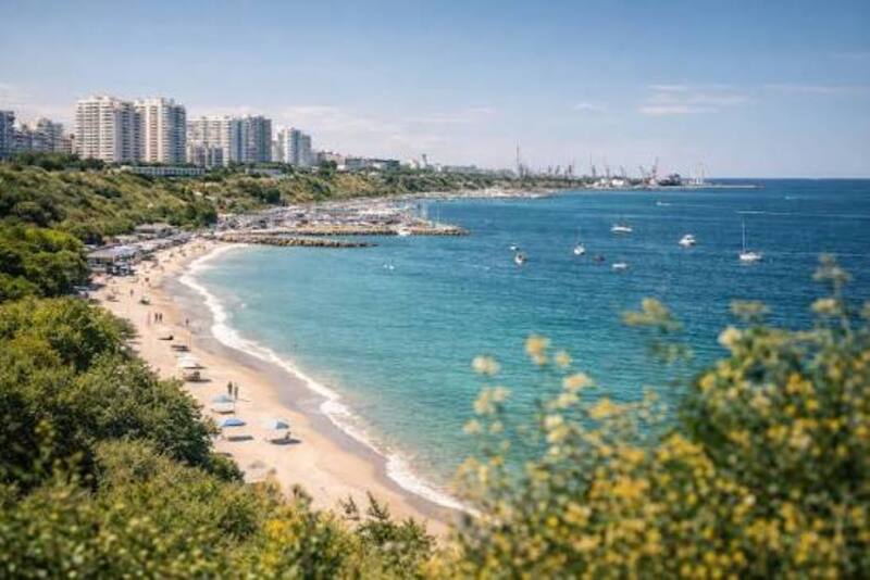 Довга полоса пляжного узбережжя. Вдалечині видно багатоповерхівки