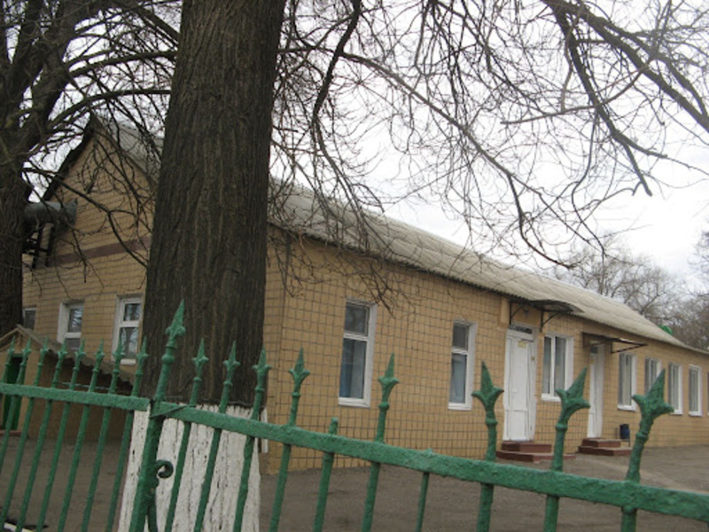 Жовтий будинок за зеленим парканом
