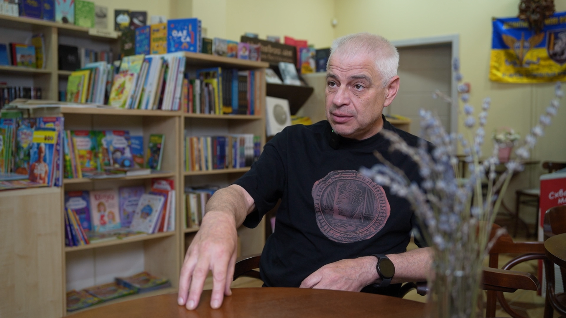 Геннадій Сульдін сидить за столом і щось пояснює