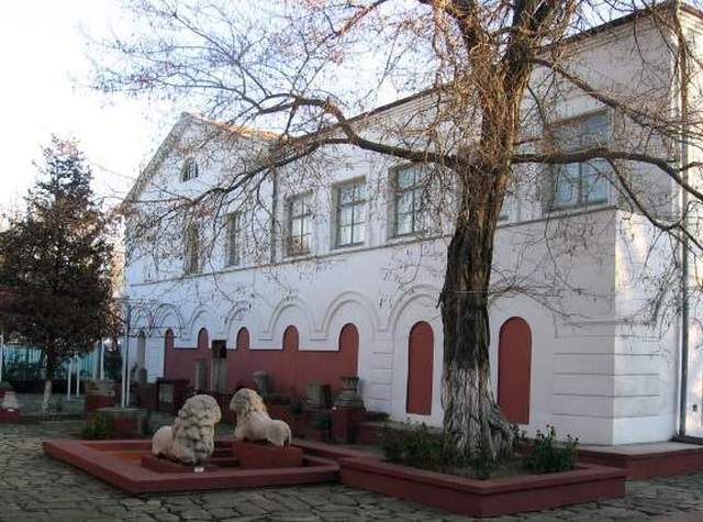 Красивий біло-червоний будинок, навколо скульптури