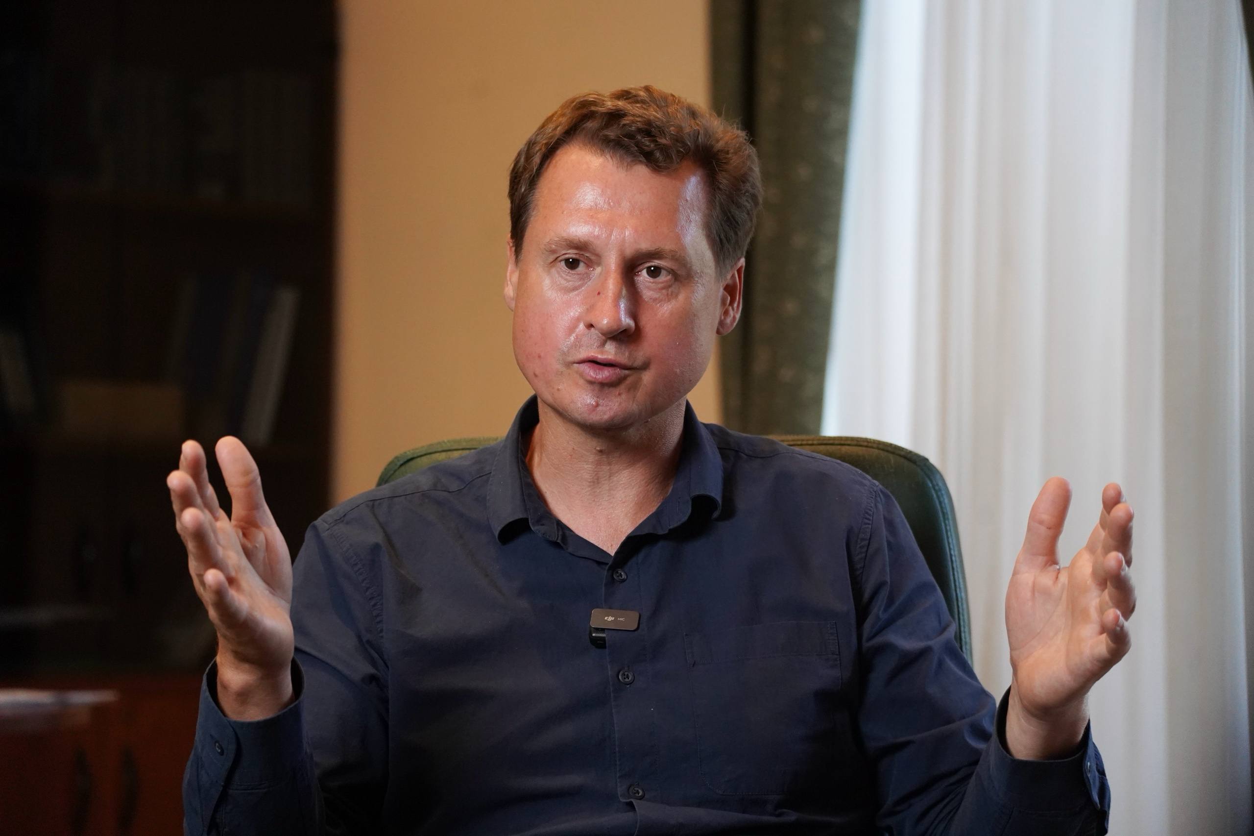 Чоловік щось показує жестами рук