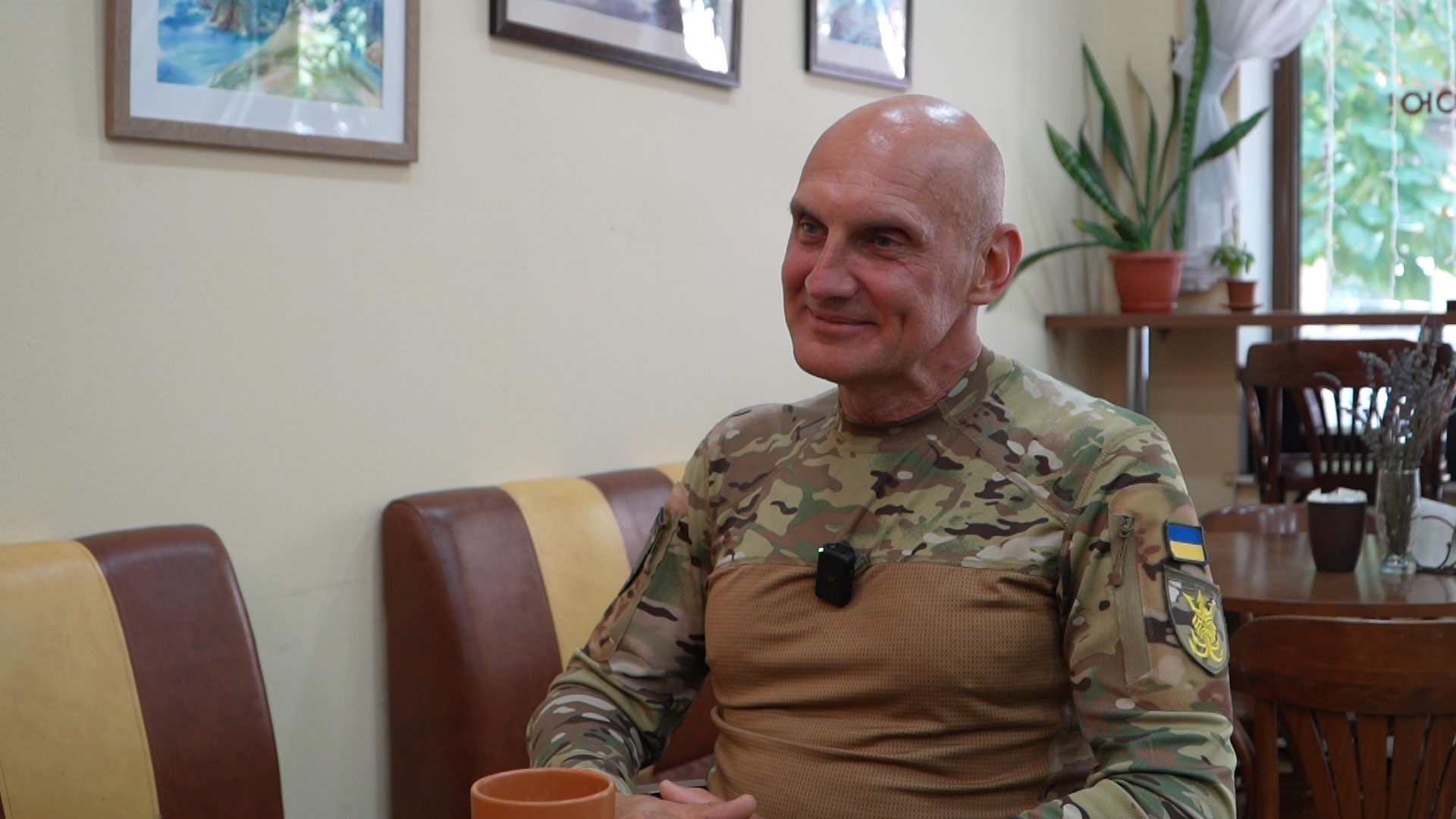 Чоловік у військовій формі сидить у кав'ярні