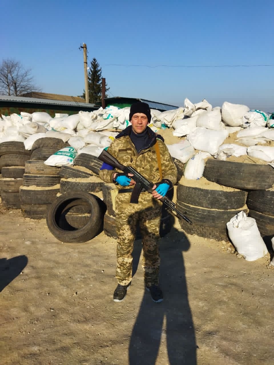 Чоловік стоїть з автоматом